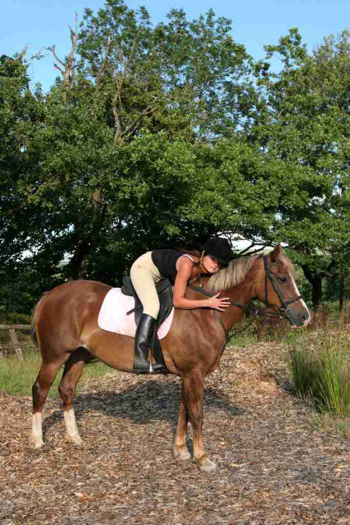 women on horse hugging his neck.