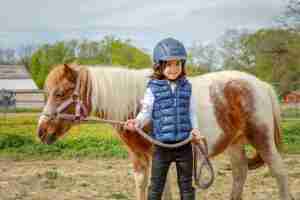 boy ridding mini horse